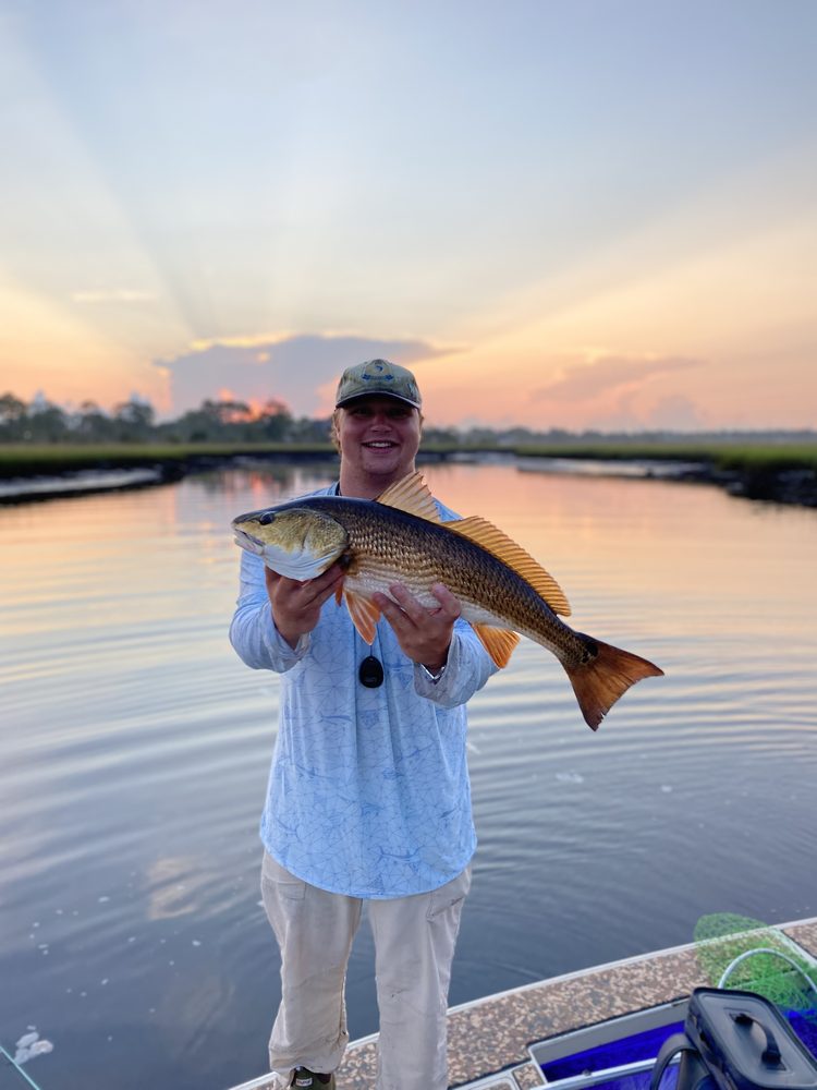 Angler holding a redfish at sunset on the Intracoastal