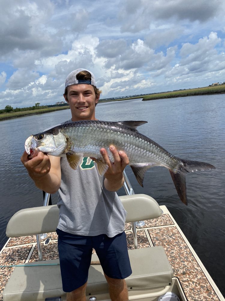 Angler on the skiff holding a tarpon
